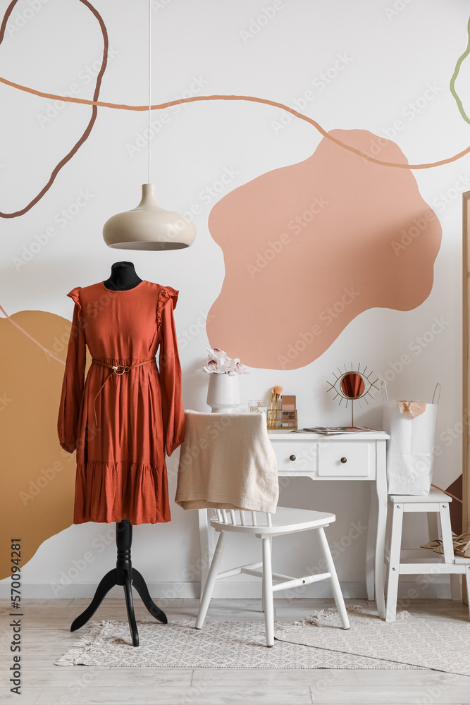 Interior of fashion designers studio with mannequin in red dress and workplace