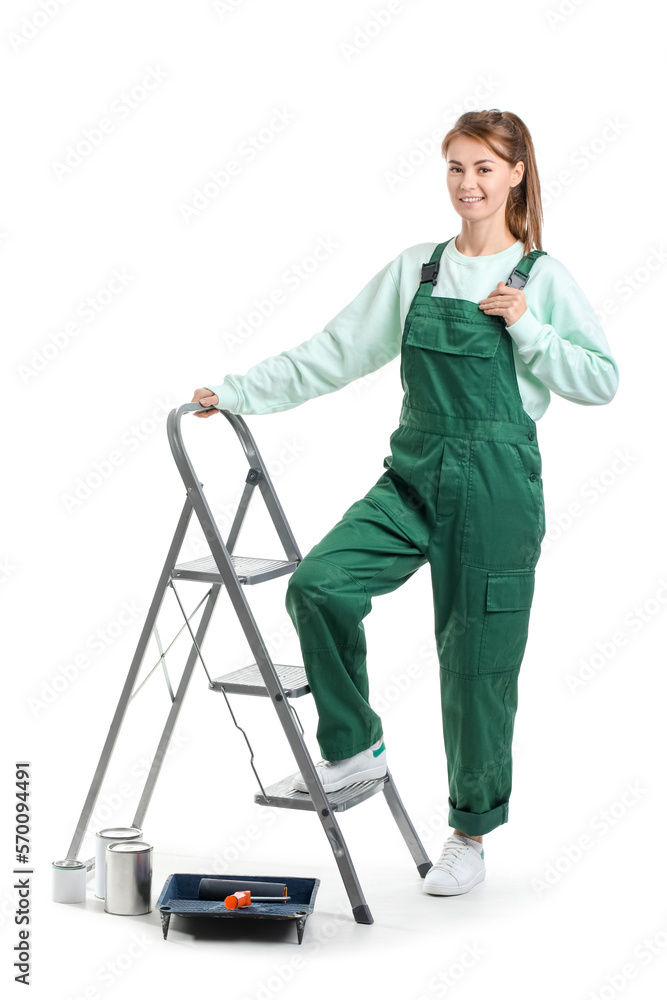 Young woman with ladder and paint cans on white background