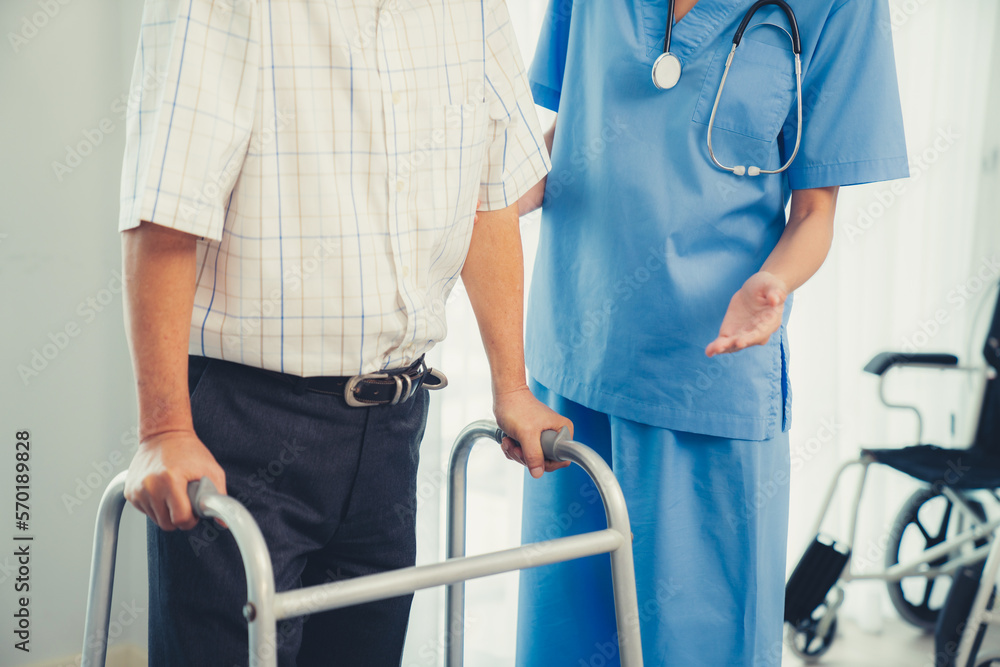 Physiotherapist assists contented senior man on folding walker. Recuperation for elderly, seniors ca