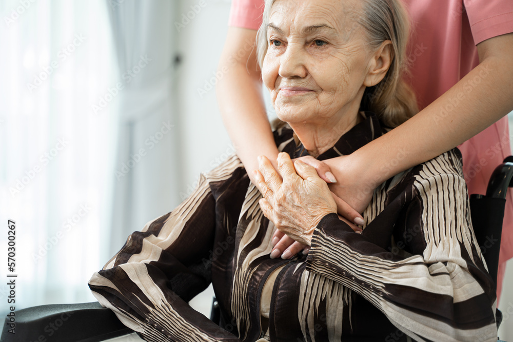 Female caregiver holding hands lady patient of nursing home,Expressing empathy and understanding.