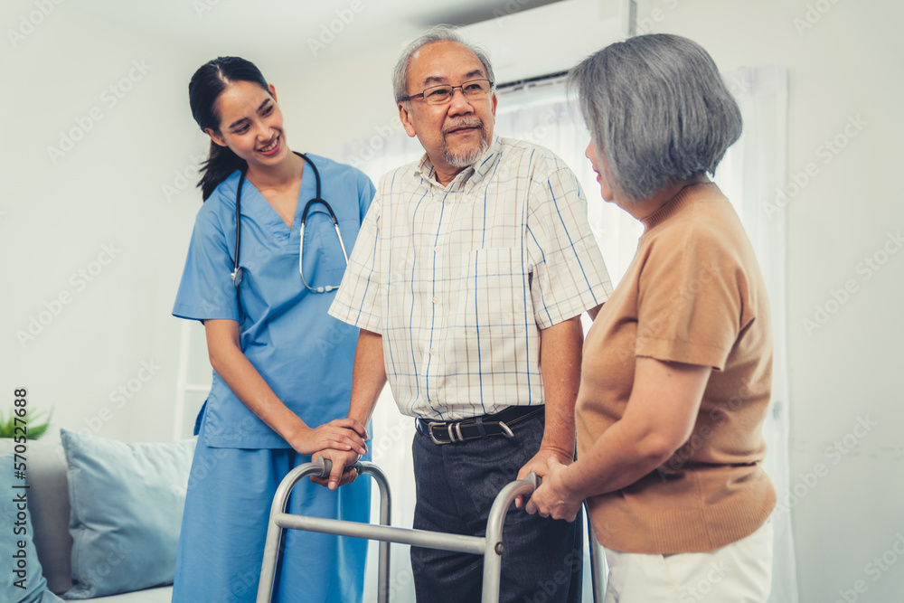 Contented senior man walking as he is helped by his wife and caretaker, walking with the aid of a fo