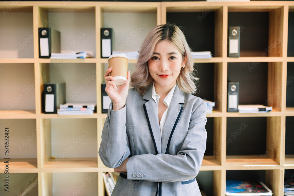 Confident female entrepreneur looking at the camera while standing. Young businesswoman standing in 