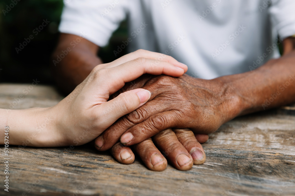 Young man holding senior woman hands, closeup