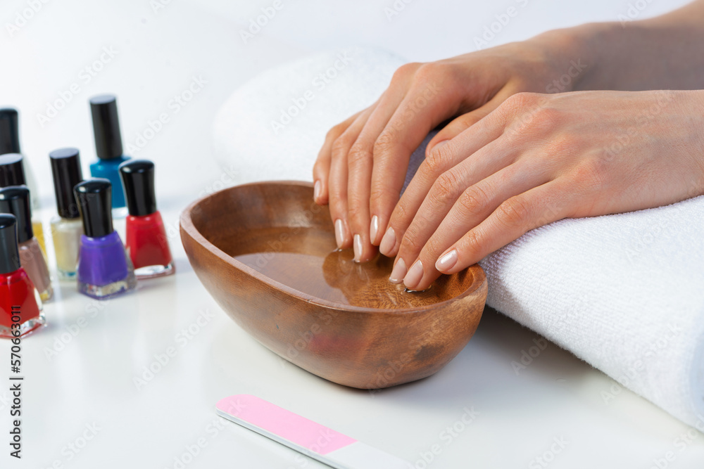 Closeup female hands in wooden bowl with water