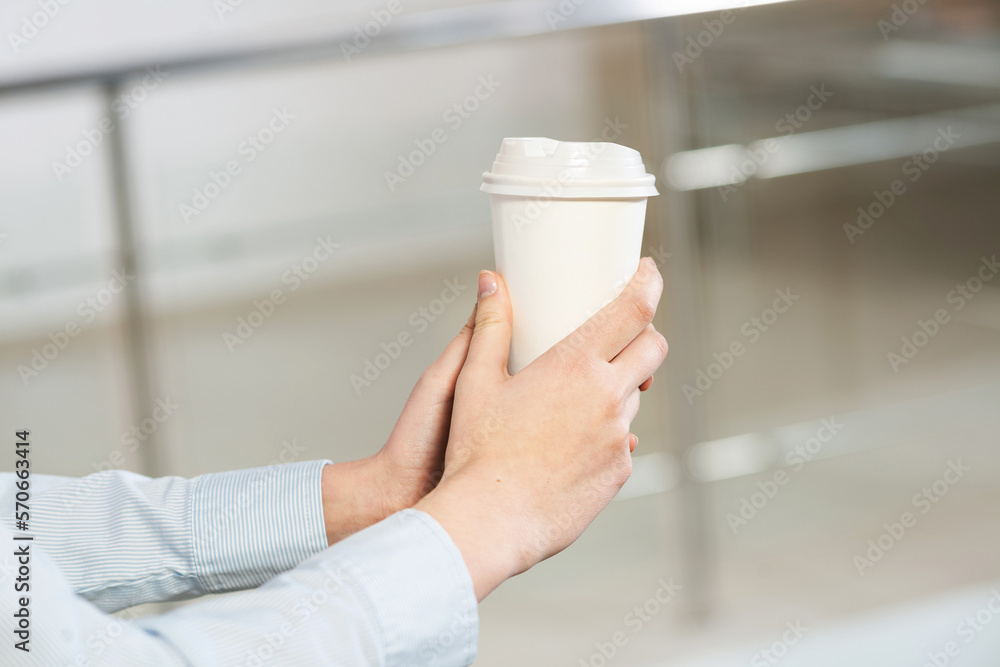 close-up of womens hands with a cup of coffee