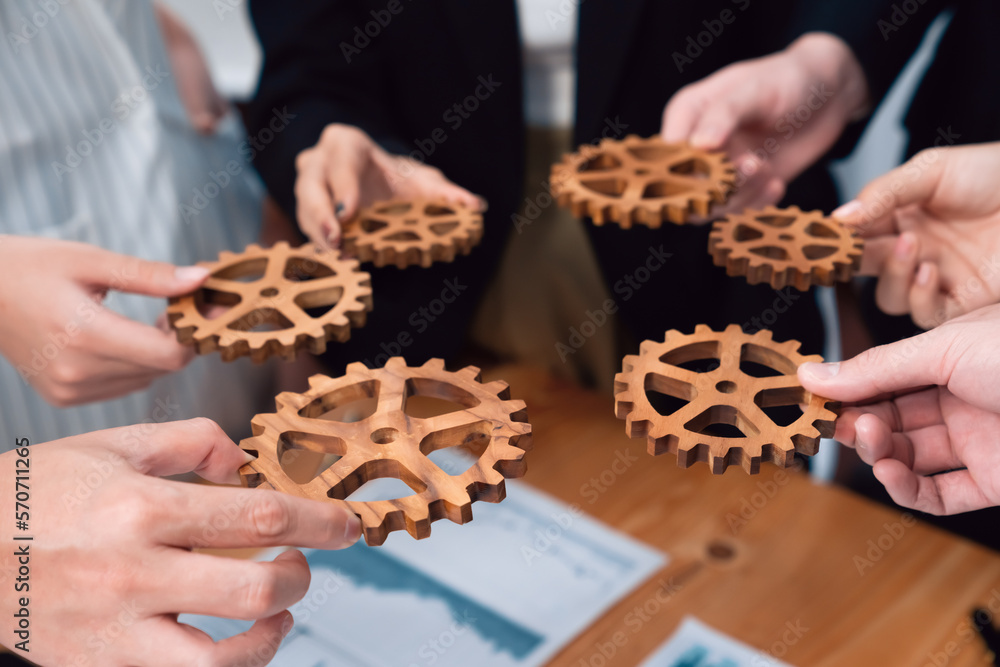 Closeup top view businesspeople hand holding gear and join together over meeting table with financia