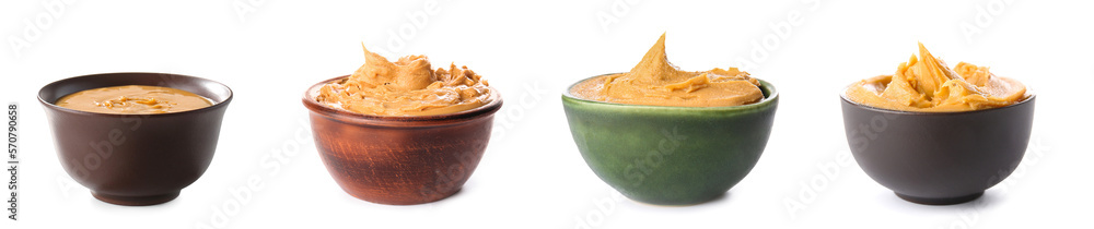 Set of tasty peanut butter in bowls on white background