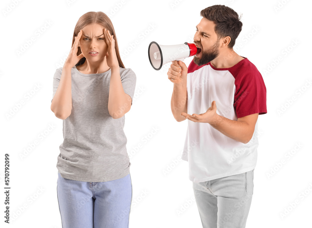 Young man with megaphone shouting at his wife on white background