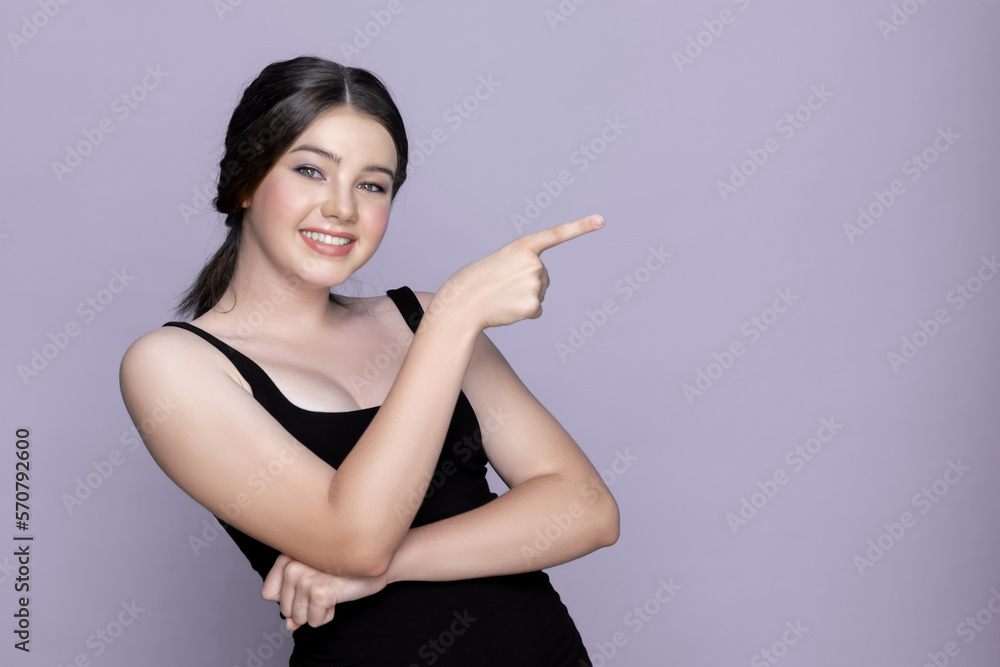 Young charming caucasian teenager girl with clean and fresh skin posing pointing fingers on empty ba