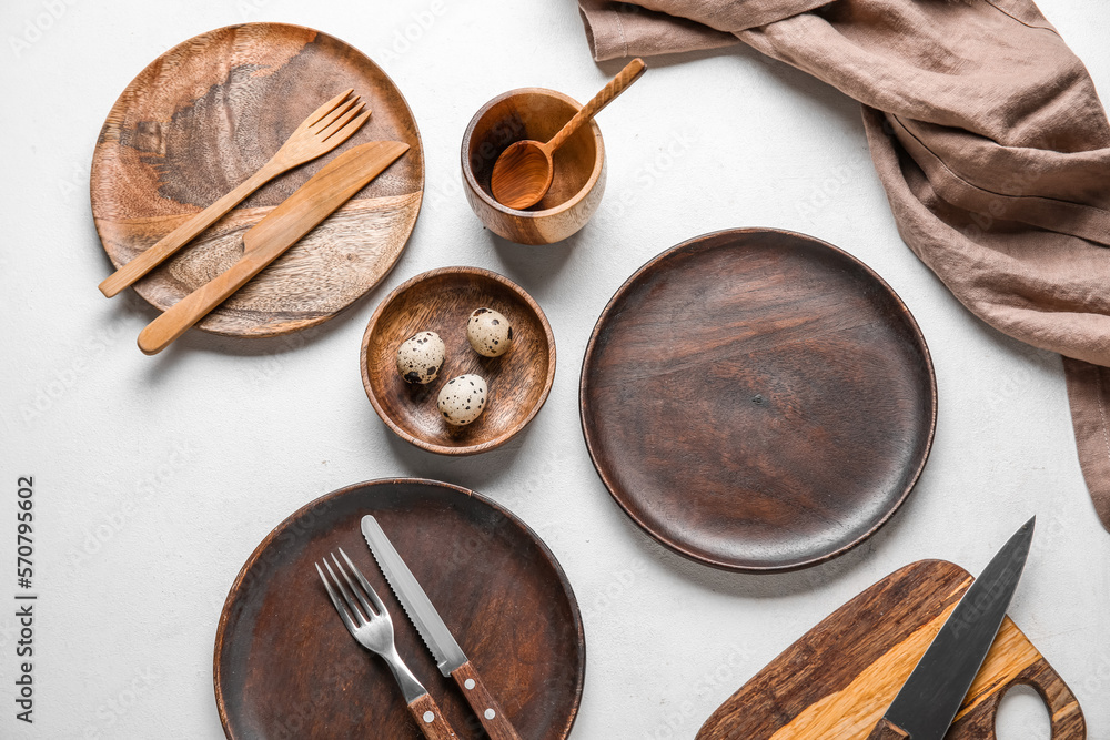 Beautiful table setting with wooden plates and quail eggs on white background