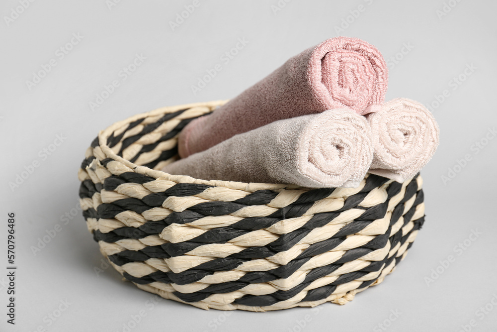 Basket with rolled towels on white background