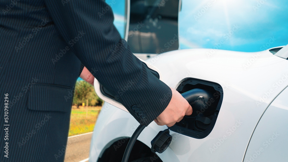 Progressive man stop to recharge energy from charging station at remote area before reach destinatio