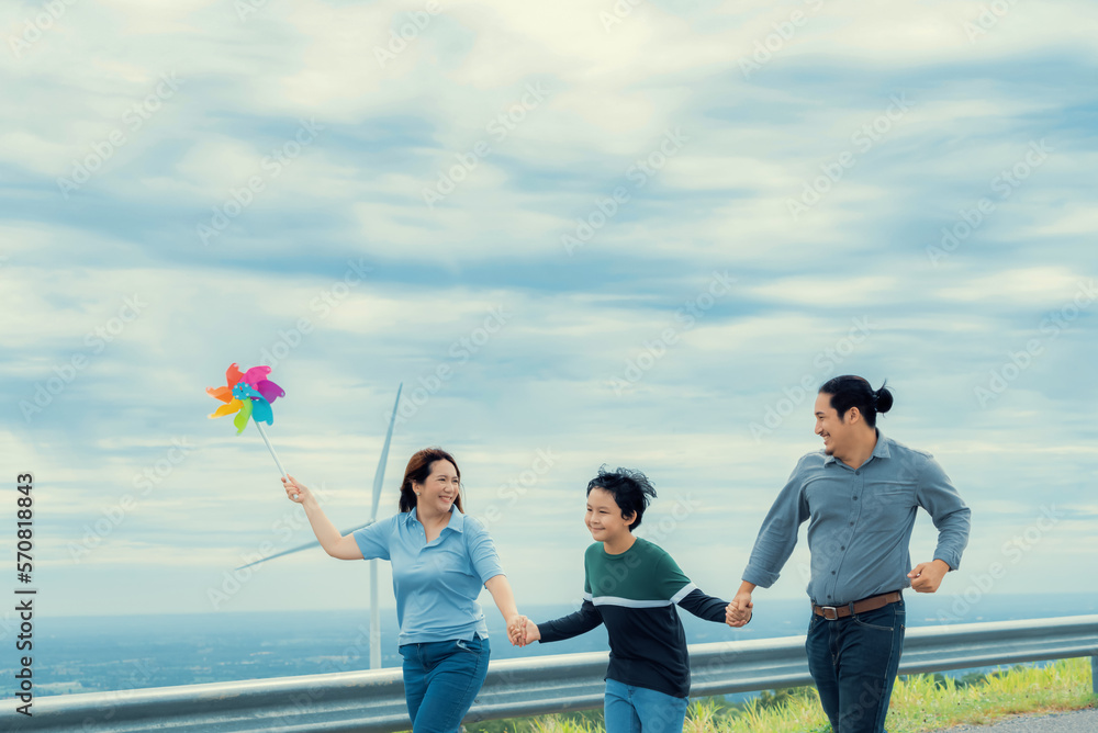 Progressive happy family enjoying their time at wind farm for green energy production concept. Wind 