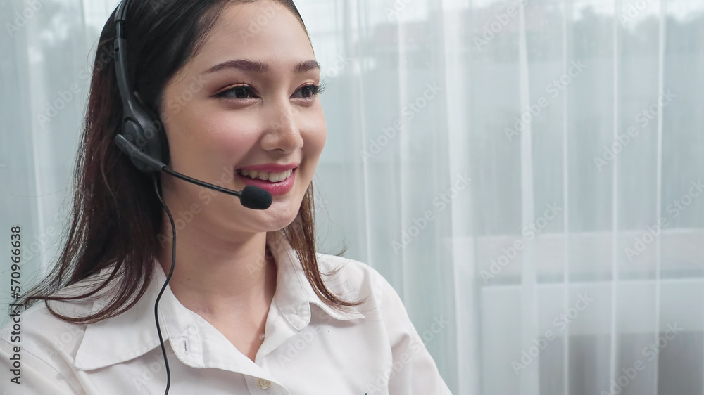 Young enthusiastic female operator put on headphone, looked into camera, and start working instantly