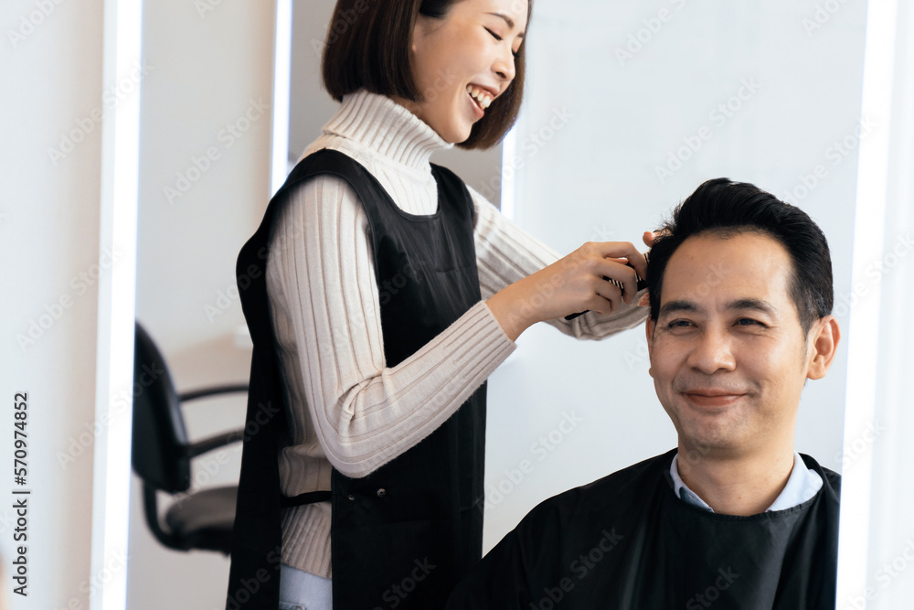 Asian female barber making haircut for male customer with male hairstyle in qualified barbershop. Me