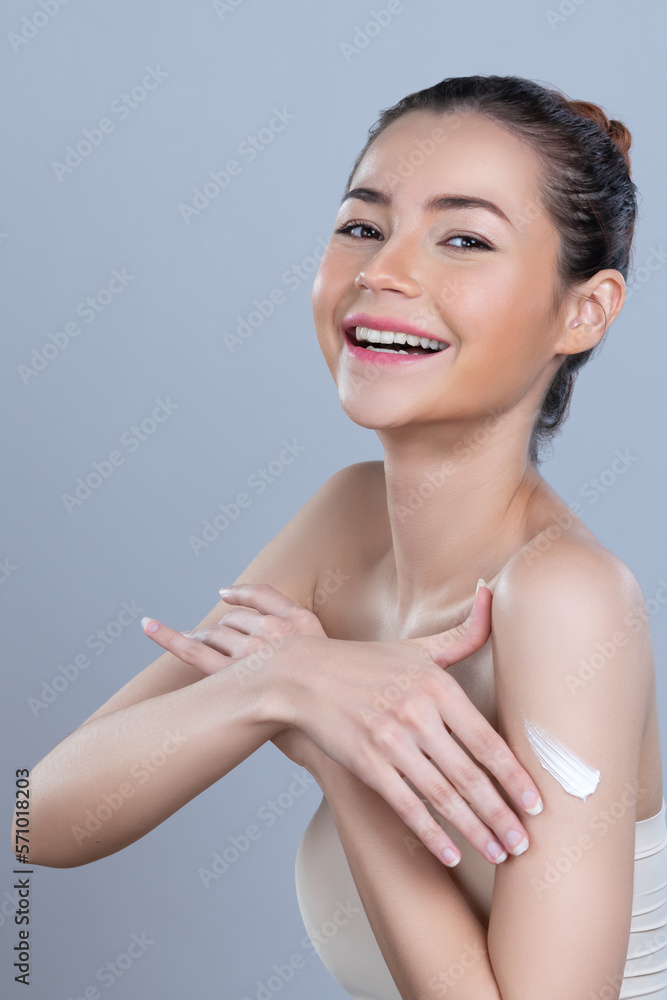 Glamorous beautiful woman applying moisturizer cream on her arm for perfect skincare treatment in is