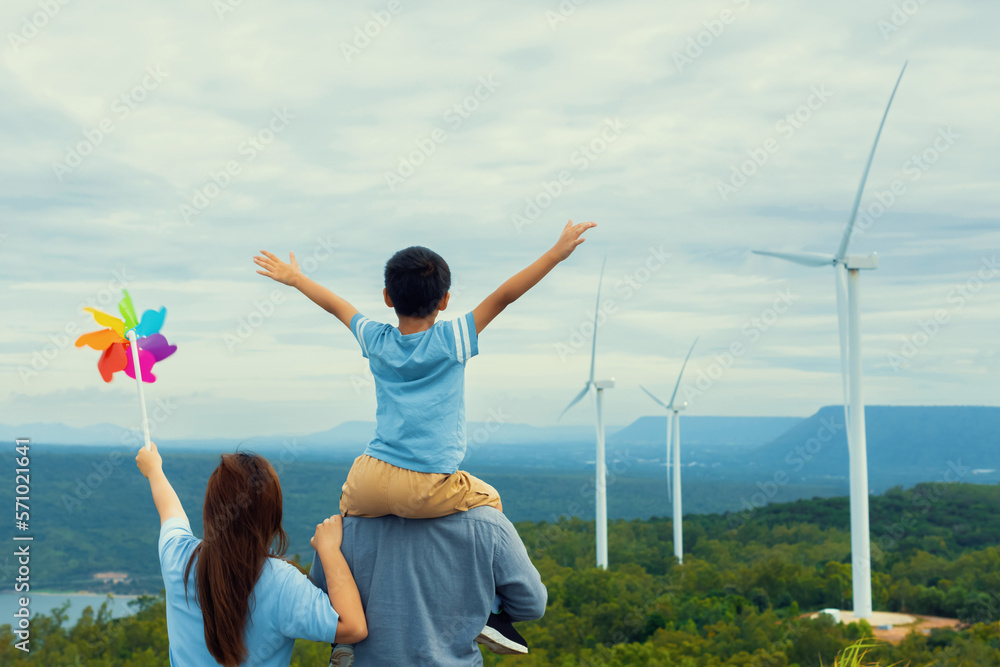 Progressive happy family enjoying their time at wind farm for green energy production concept. Wind 