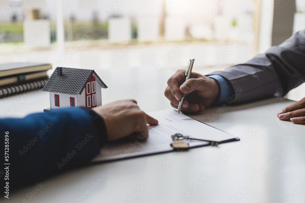 Businessmen and real estate agents sign contracts to legally sell homes.