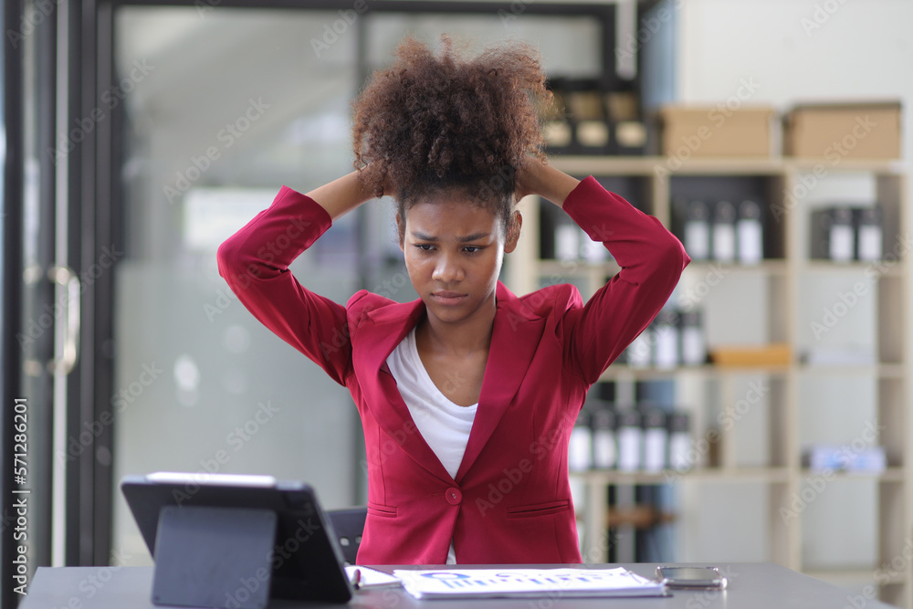 Serious african woman in office stressed and worried about unsuccessfully working on deadlines. Stre