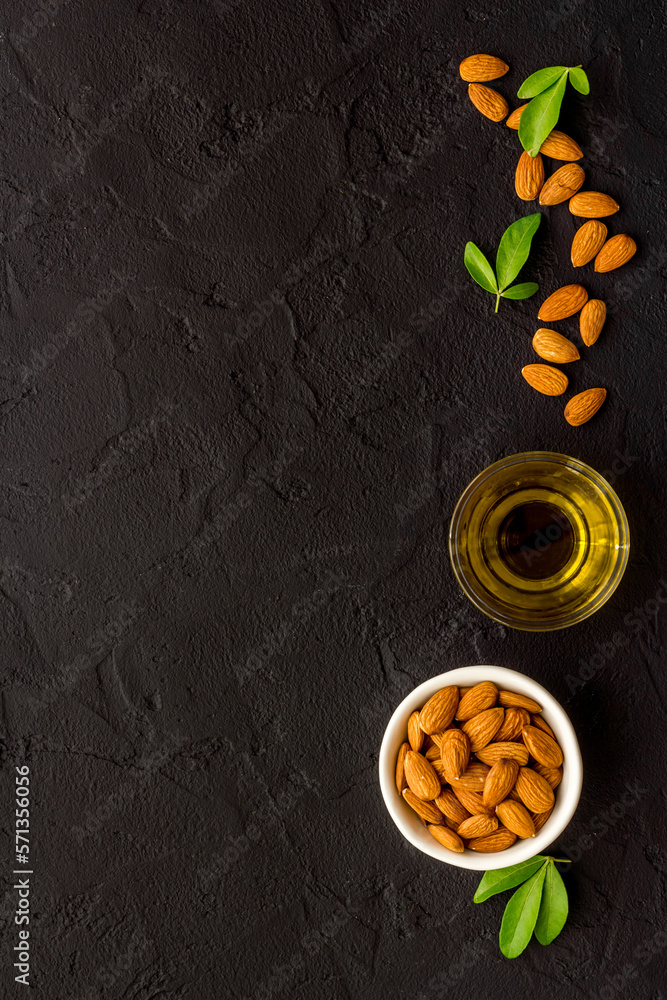 Almond oil and group of almond nuts with leaves