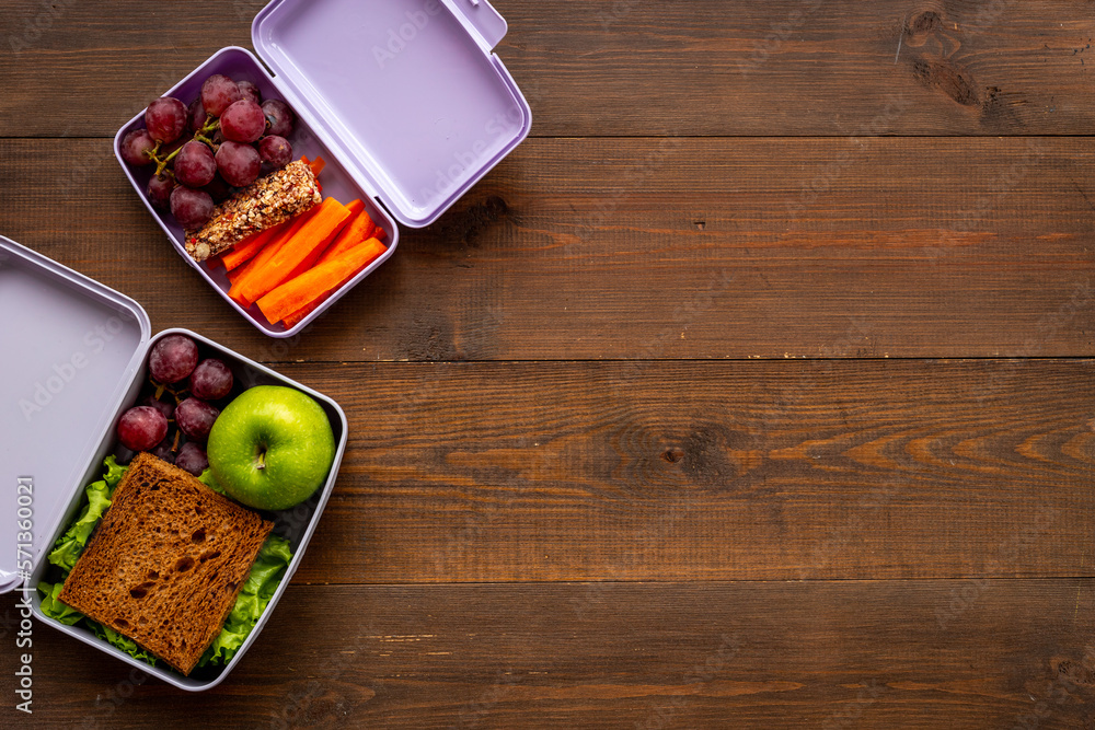 Healthy lunch boxes filled with fruits and vegetables, top view