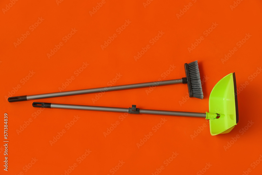 Cleaning broom with green dustpan on color background