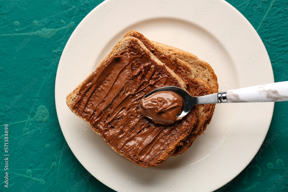 Plate of tasty toasts with hazelnut butter on color background, closeup