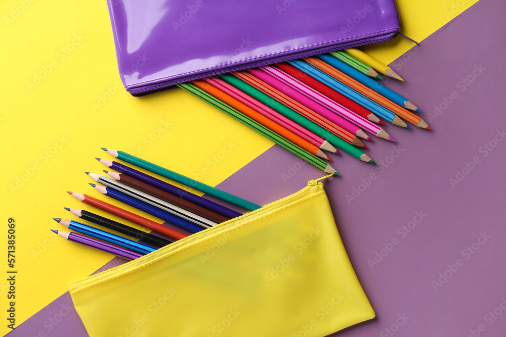 Cases with colorful pencils on color background