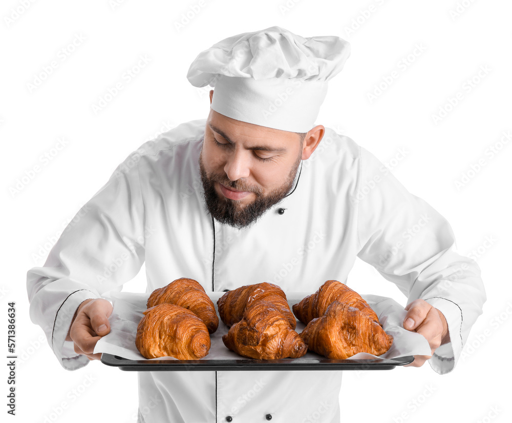 Male baker with tray of tasty croissants on white background