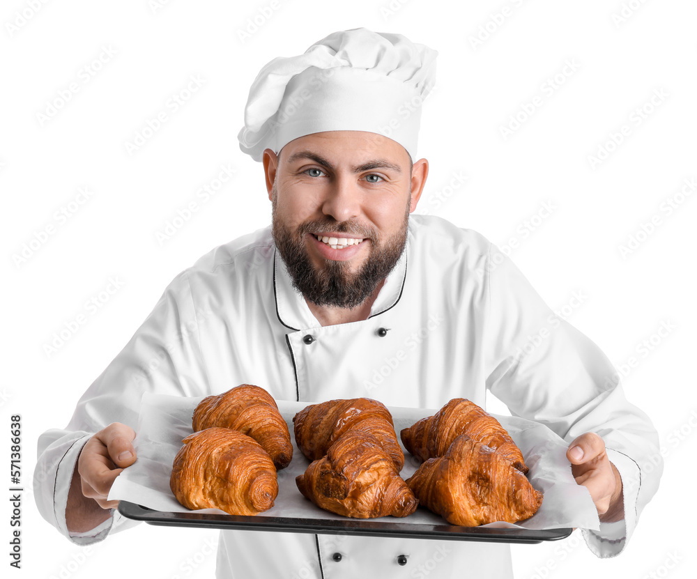 Male baker with tray of tasty croissants on white background