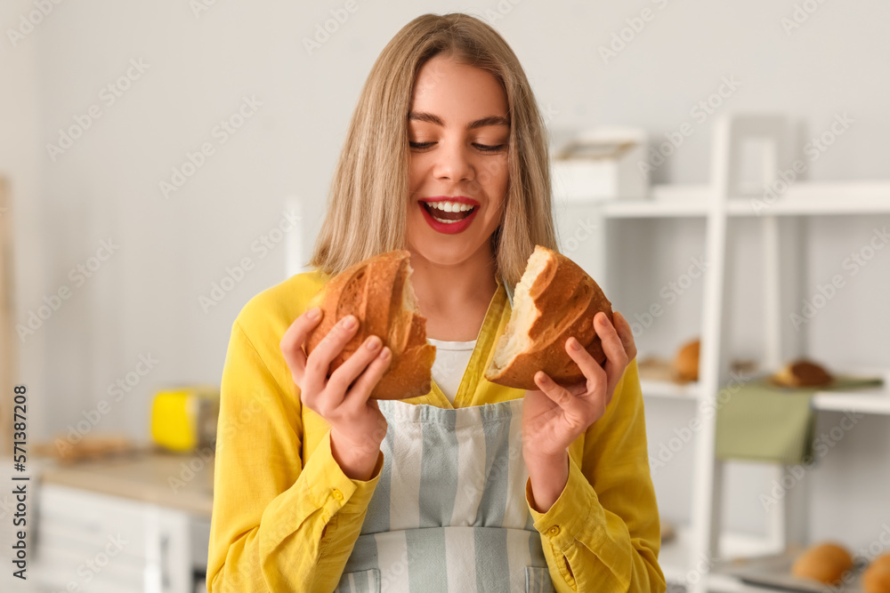 Female baker with fresh bread in kitchen