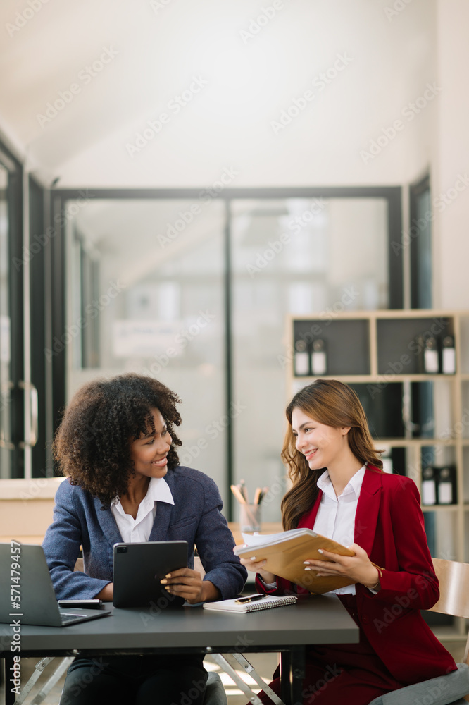 Two businesswoman discuss investment project working and planning strategy with tablet laptop comput