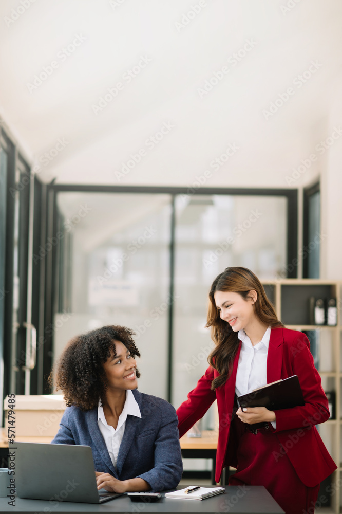 Two businesswoman discuss investment project working and planning strategy with tablet laptop comput