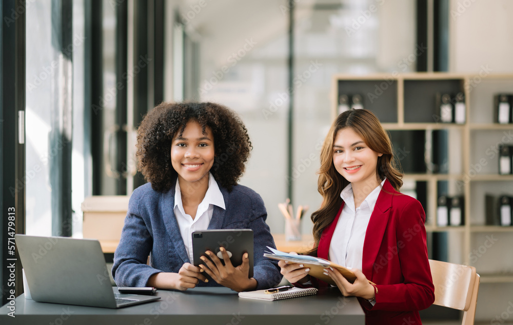 Two businesswoman discuss investment project working and planning strategy with tablet laptop comput