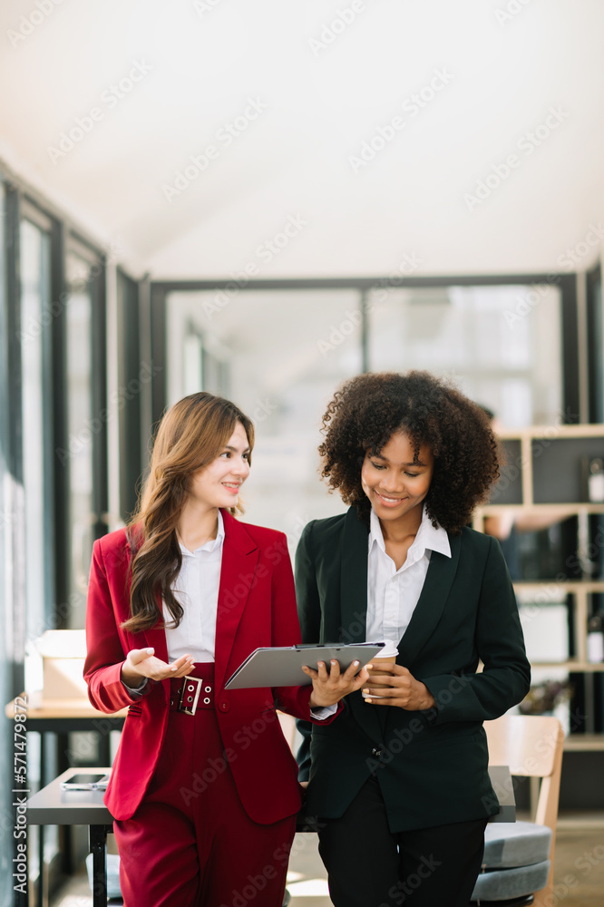 Businesswomen work and discuss their business plans. A Human employee explains and shows her colleag