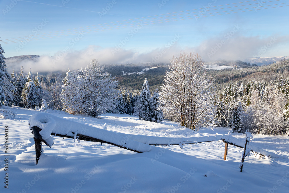 Winter landscape of Beskid Mountains in Poland, forest and mountain glade with wooden fence covered 