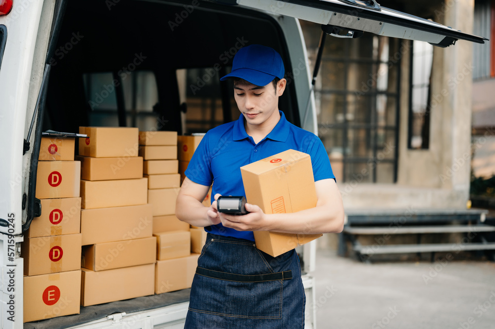 Happy delivery man standing with arms crossed near van outside the warehouse. This is a freight tran