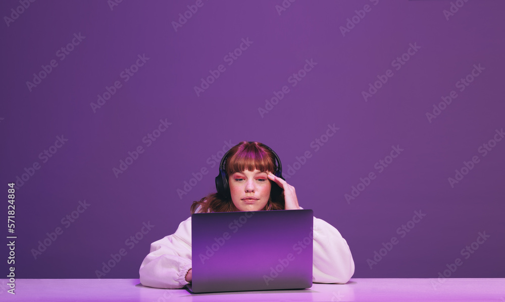 Woman thinking while playing an online video game