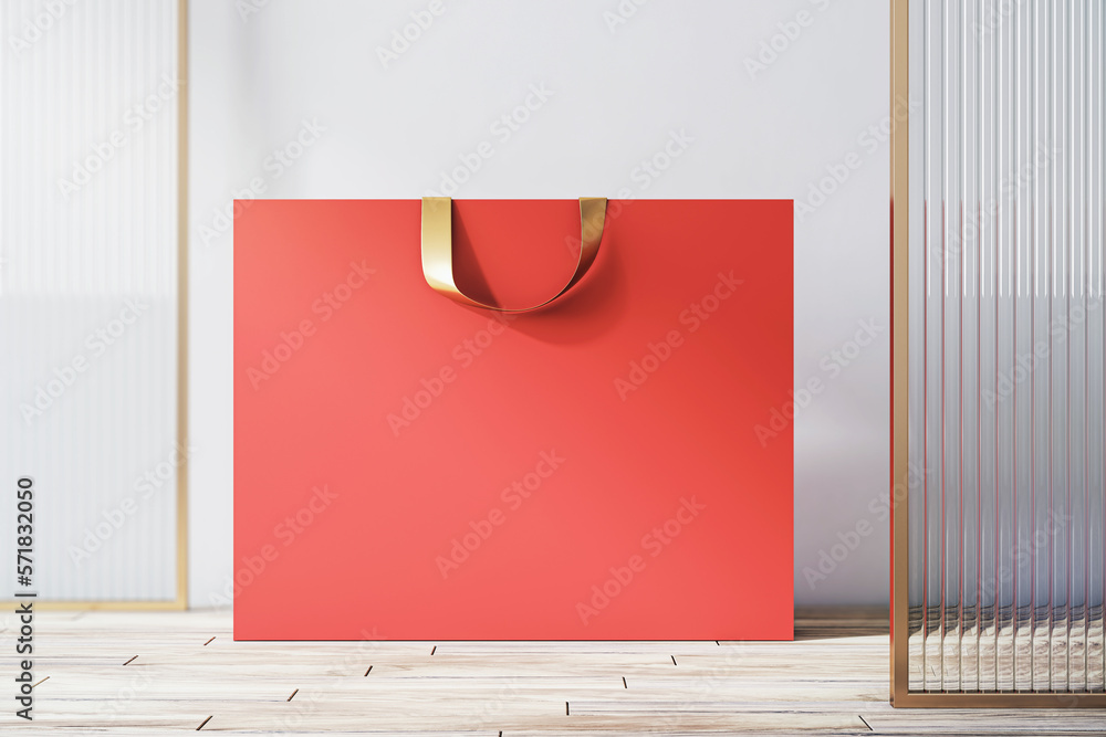 Front view on blank red paper shopping bag with place for your brand name or text on light wooden fl