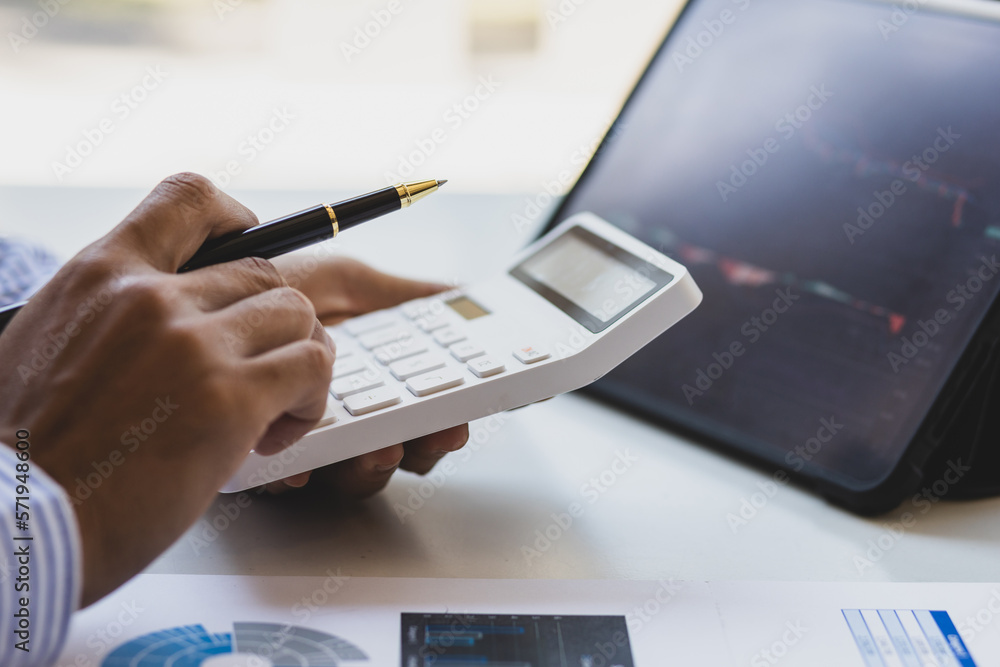 Businessman working on tablet analysis stock market investment graph. Investors analyzing stock mark