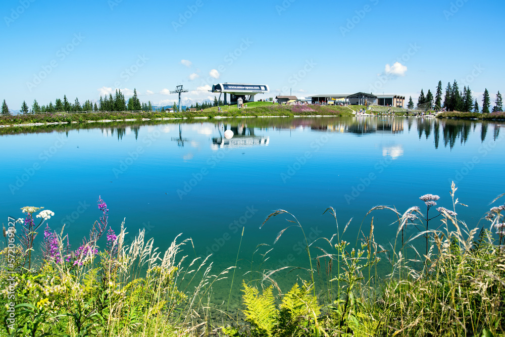 Upper station of the Grafenberg cable car, Wagrain in the Austrian Alps with a lake and blooming flo