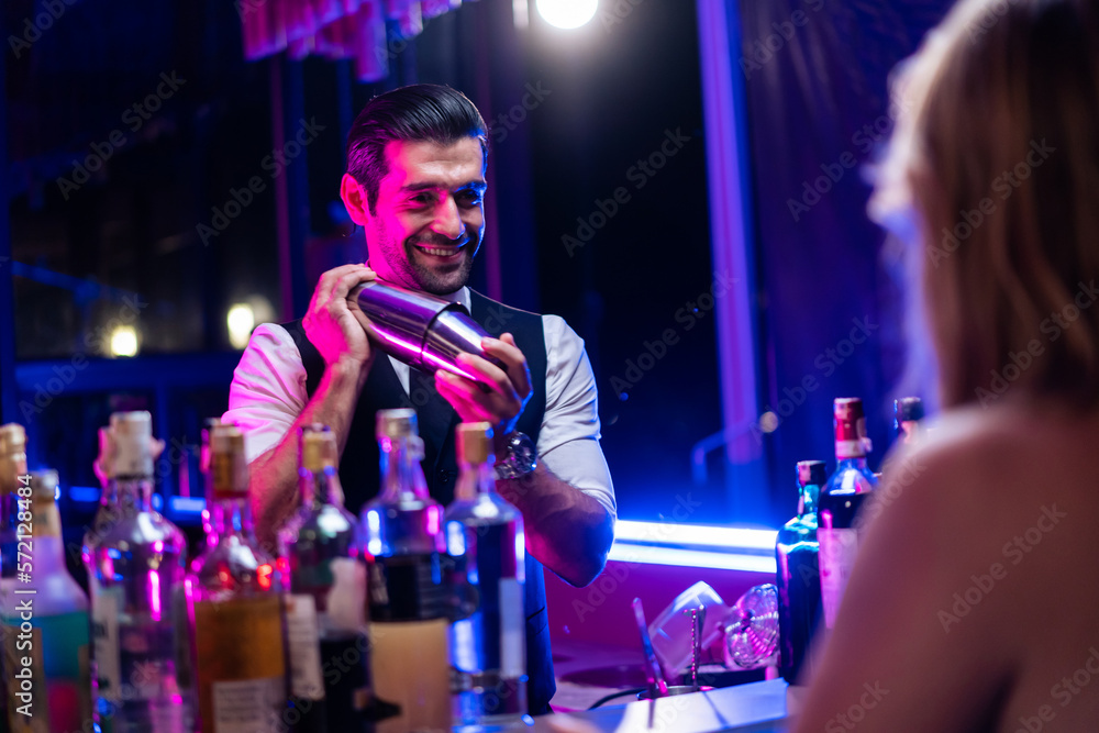 Caucasian profession bartender making a cocktail for women at a bar. 