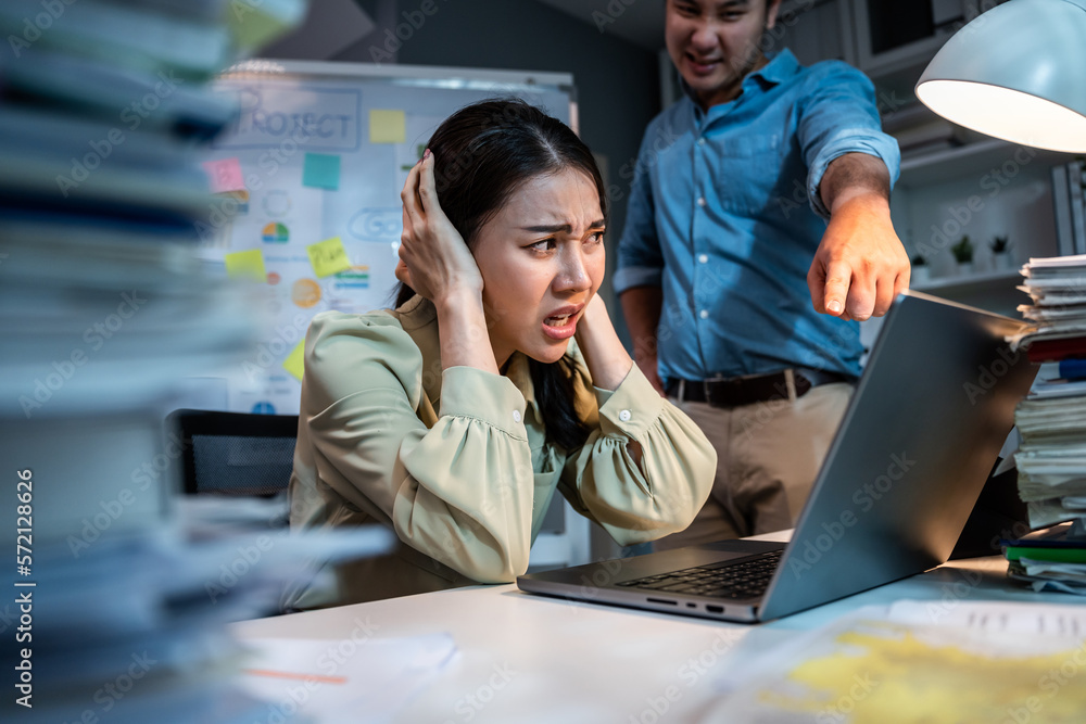 Asian frustrated businesswoman following direction from boss in office