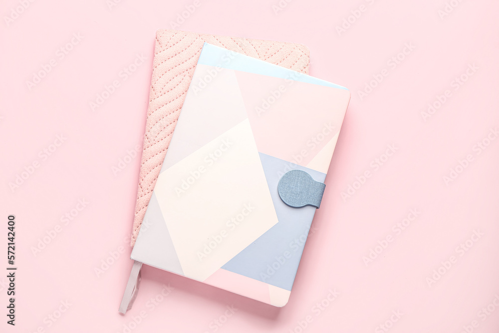 Stylish notebooks on pink background