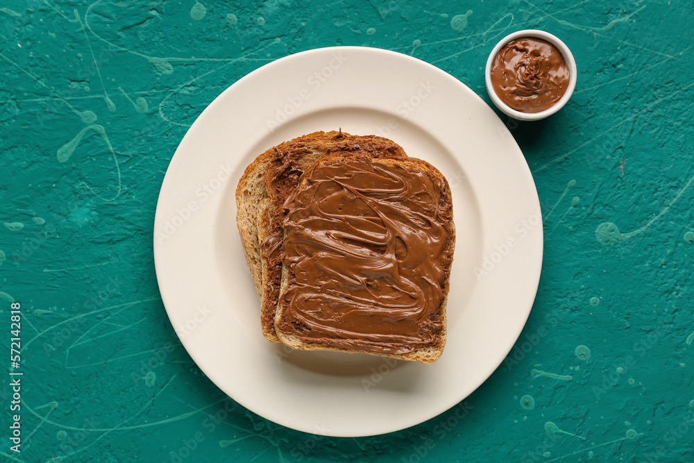 Plate of tasty toasts with hazelnut butter on color background