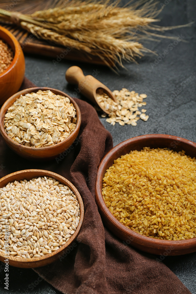 Bowls with cereals on dark background, closeup