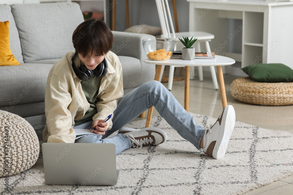 Male student with laptop studying online at home