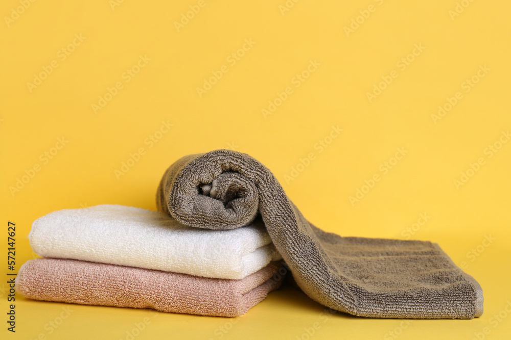 Soft clean towels on yellow background