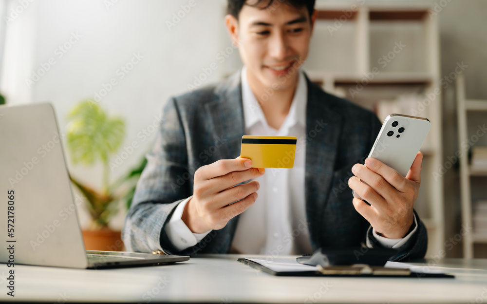 Businessman using smart phone for mobile payments online shopping,omni channel,sitting on table,virt