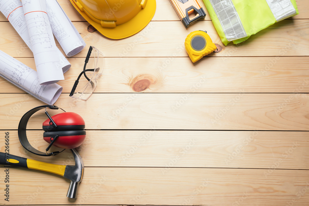 Work safety. Standard Construction site protective equipment on  top view wooden background, flat la